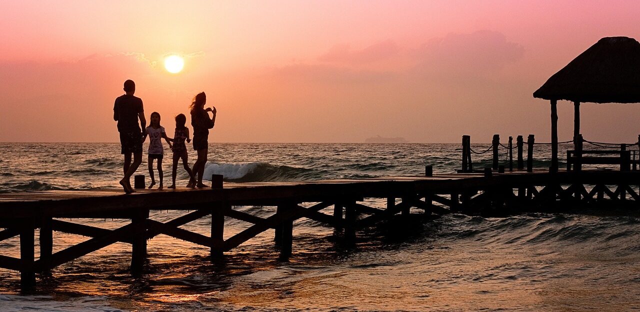 Famiglia su un pontile sul mare al tramonto