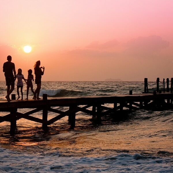 Famiglia su un pontile sul mare al tramonto